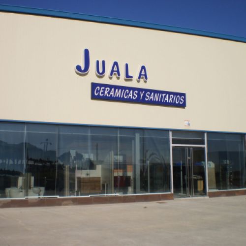 Exterior de la nave con venttanales en parte inferior y logotipo en superior